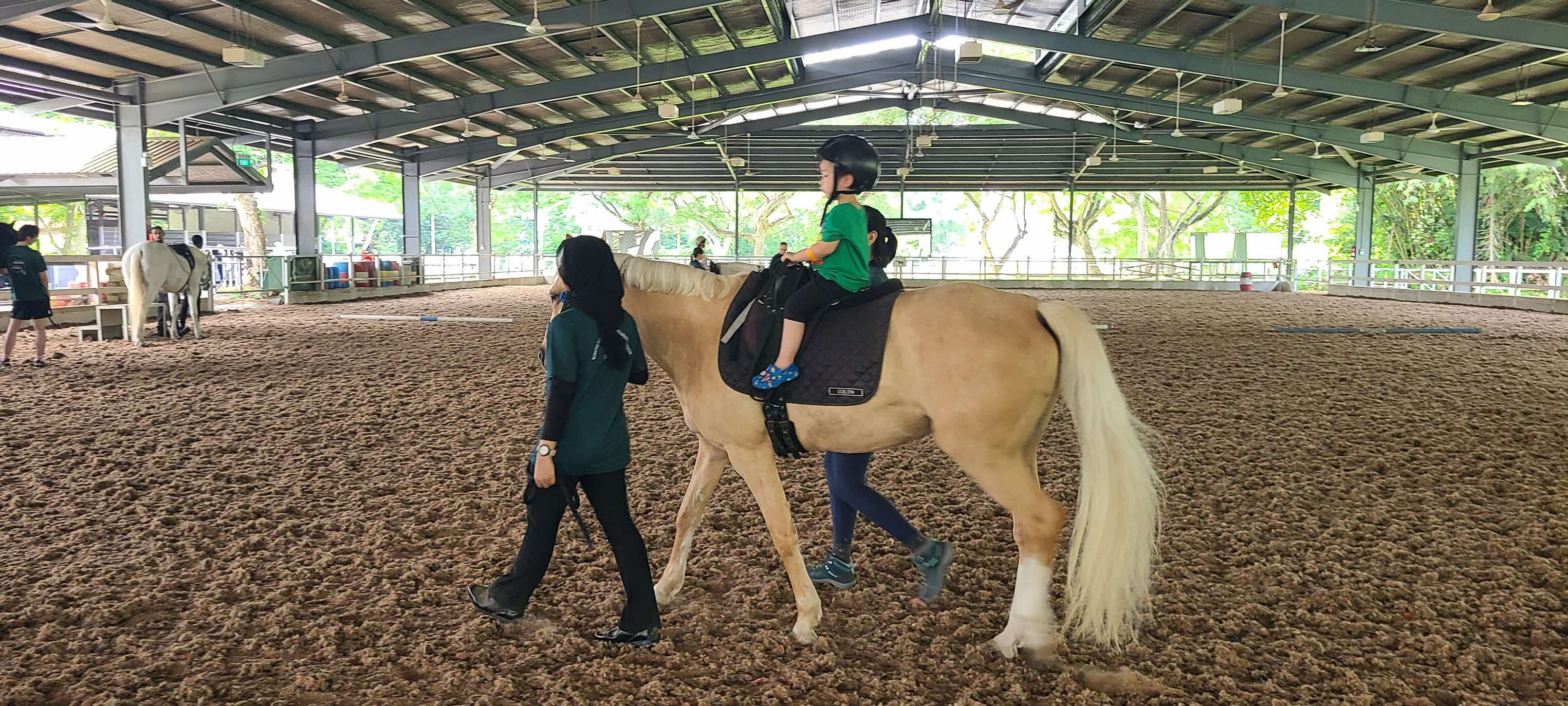 Young rider with volunteers at RDA